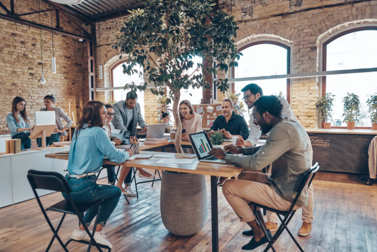 group-young-modern-people-smart-casual-wear-communicating-using-modern-technologies-while-working-office